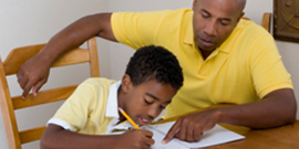 father helping son with writing homework