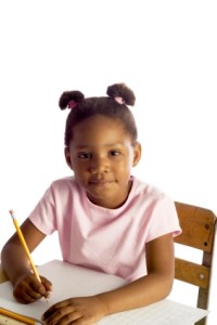 young black girl sitting at desk with pencil and paper