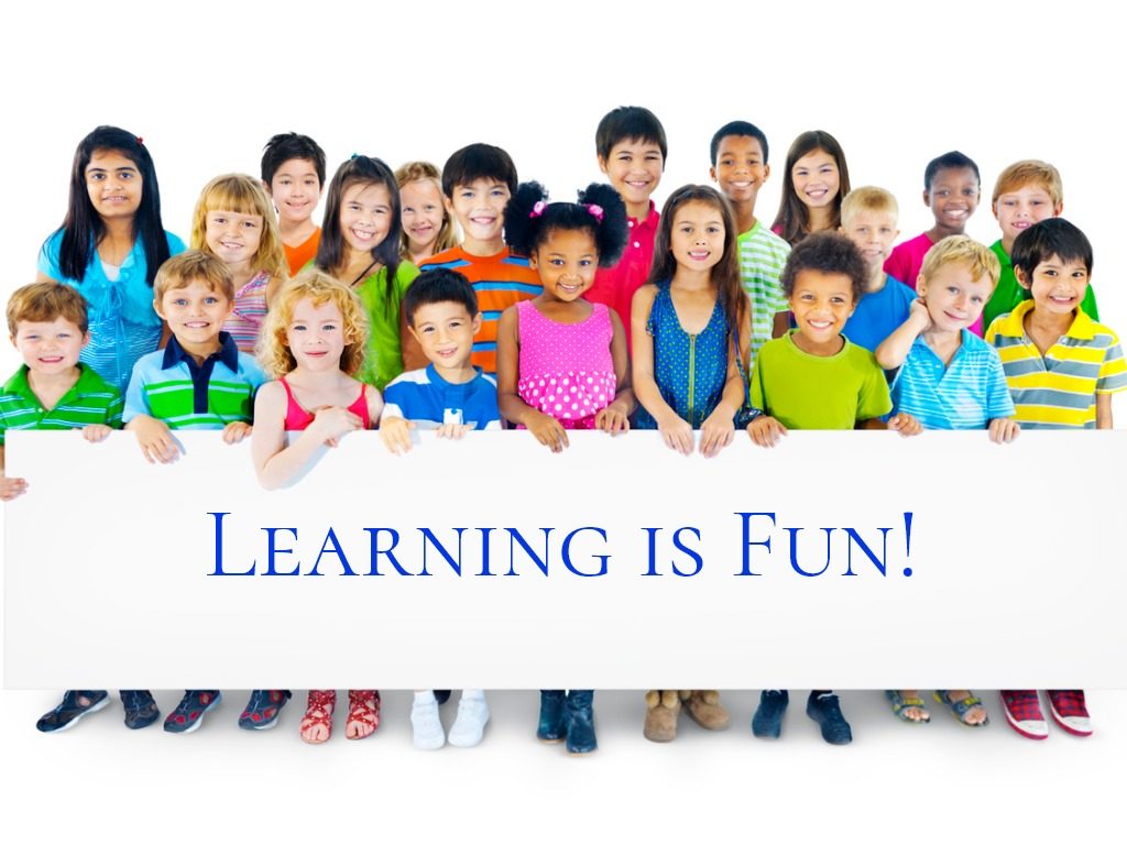 multiethnic group of children holding sign that reads learning is fun!